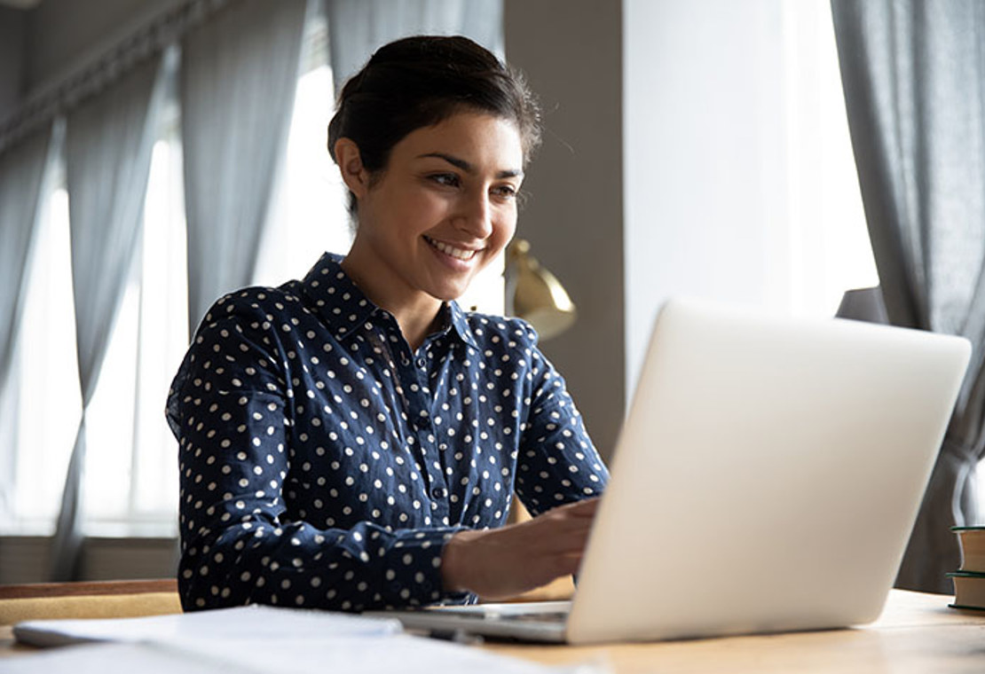 Woman smiling at computer while working