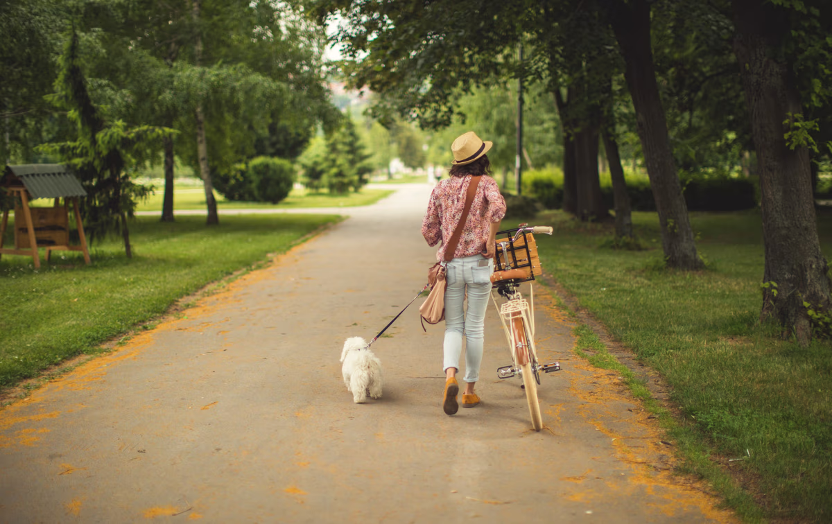 Dame som går i en park sammen med hunden sin