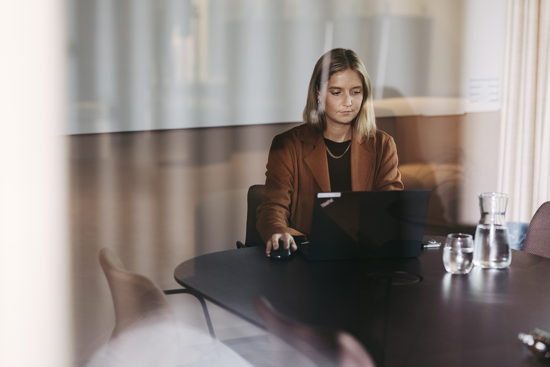 Dame som sitter på pc'en og jobber med fakturering